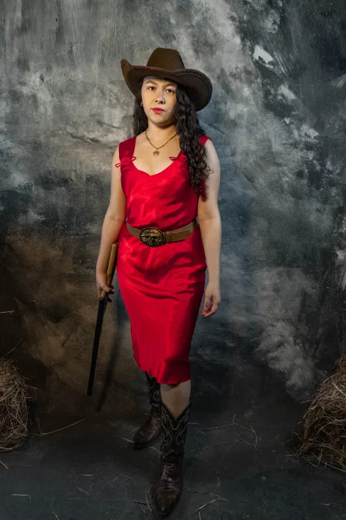 Woman dressed as a cowgirl Halloween costume with hat and plaid shirt
