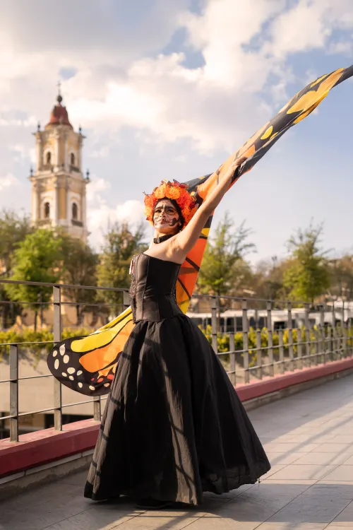 Woman in a monarch butterfly Halloween costume with orange wings