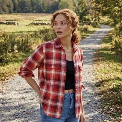 Woman wearing a red plaid flannel shirt with jeans