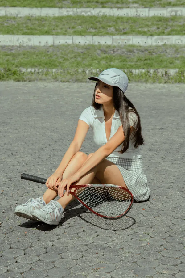 Woman wearing a tennis pro Halloween costume with white skirt