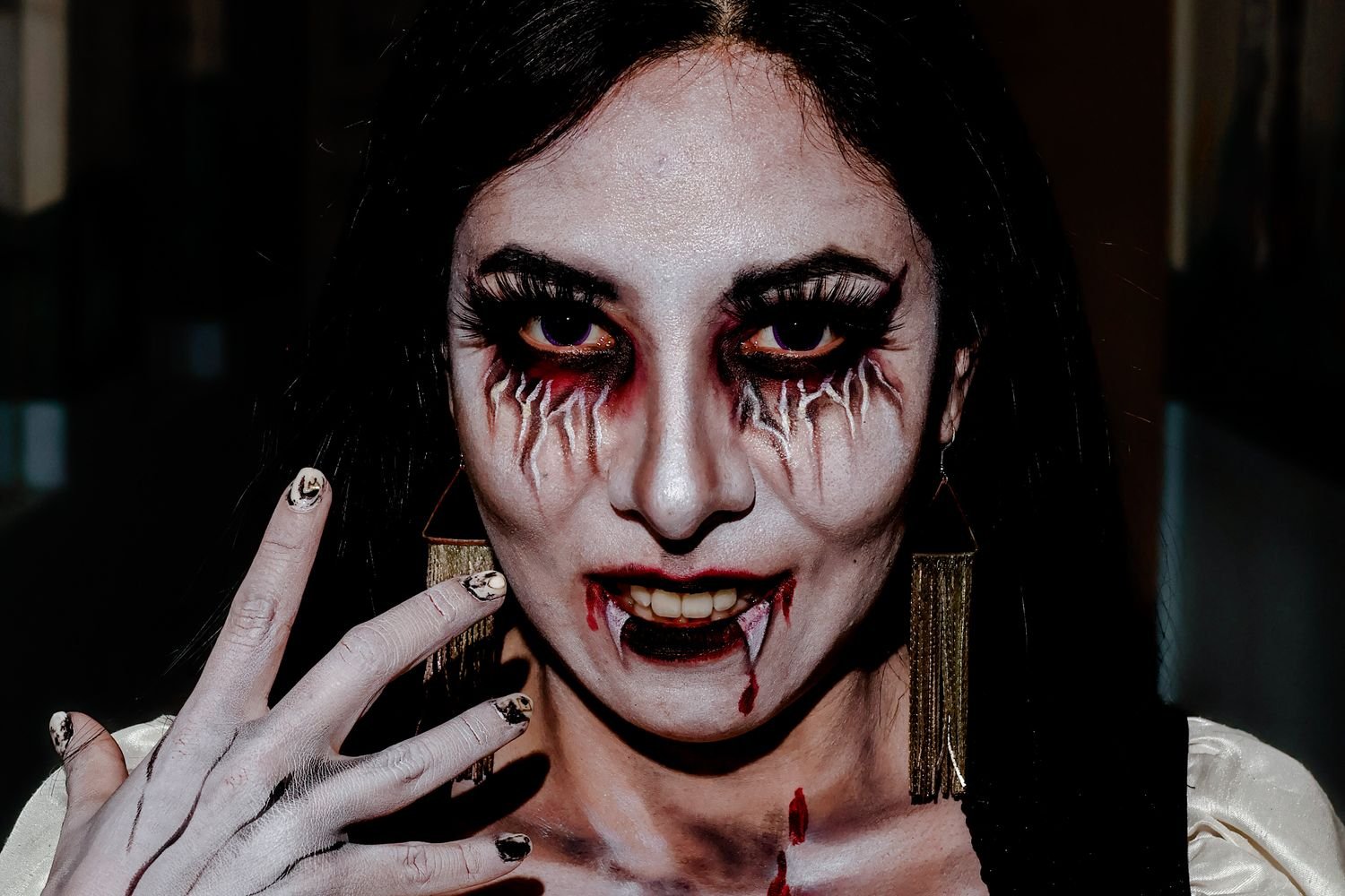 Woman dressed as a vampire queen Halloween costume with dark red lips