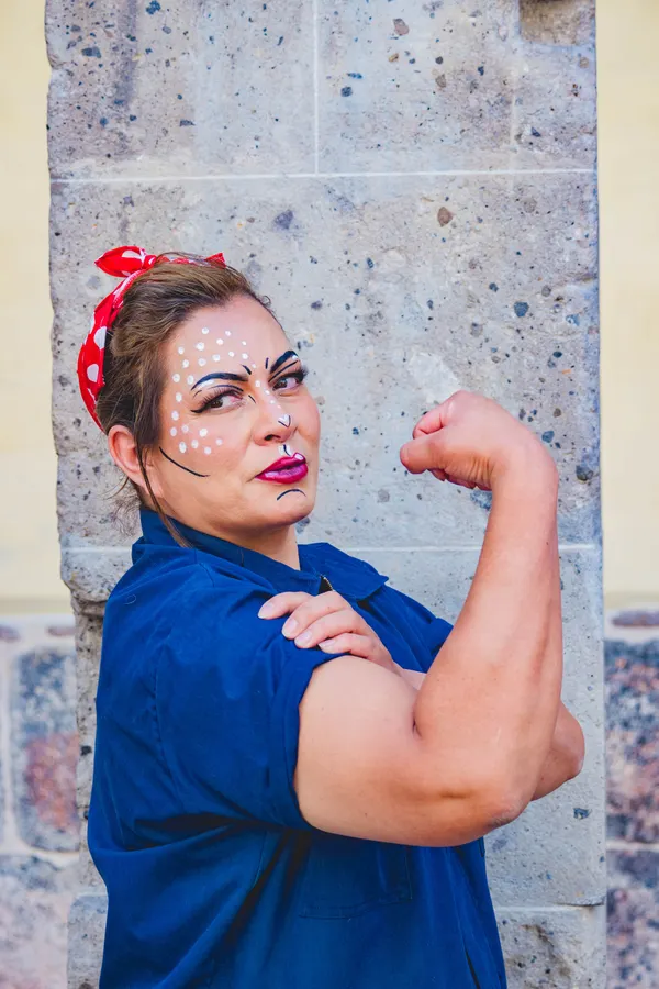 Woman in a Rosie the Riveter Halloween costume with red bandana