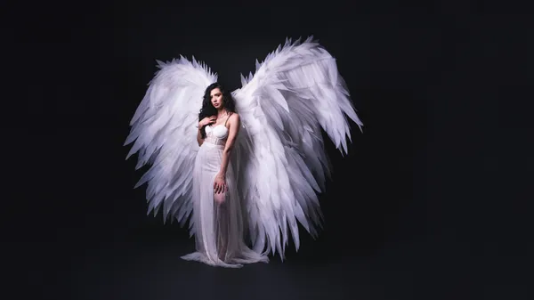 Woman dressed as an angel Halloween costume with white wings