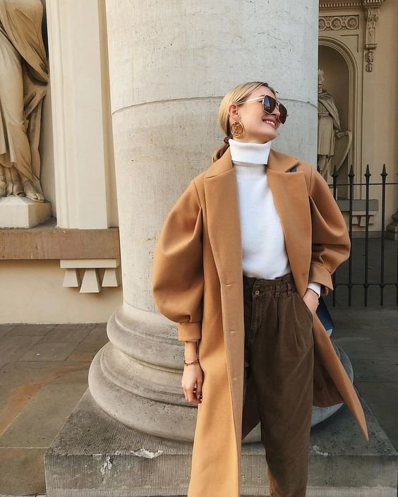 Woman wearing a long camel corduroy coat over a fall outfit