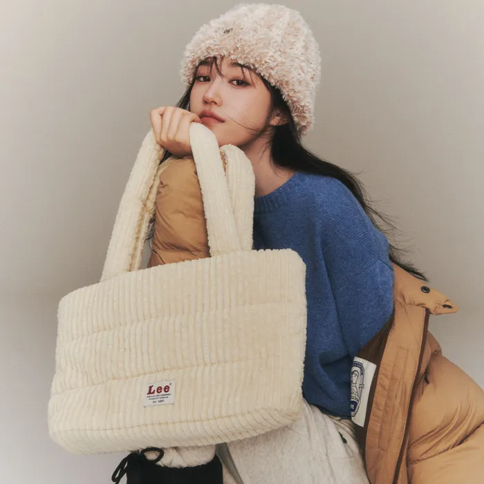 Woman styling corduroy accessories including a tote bag for fall