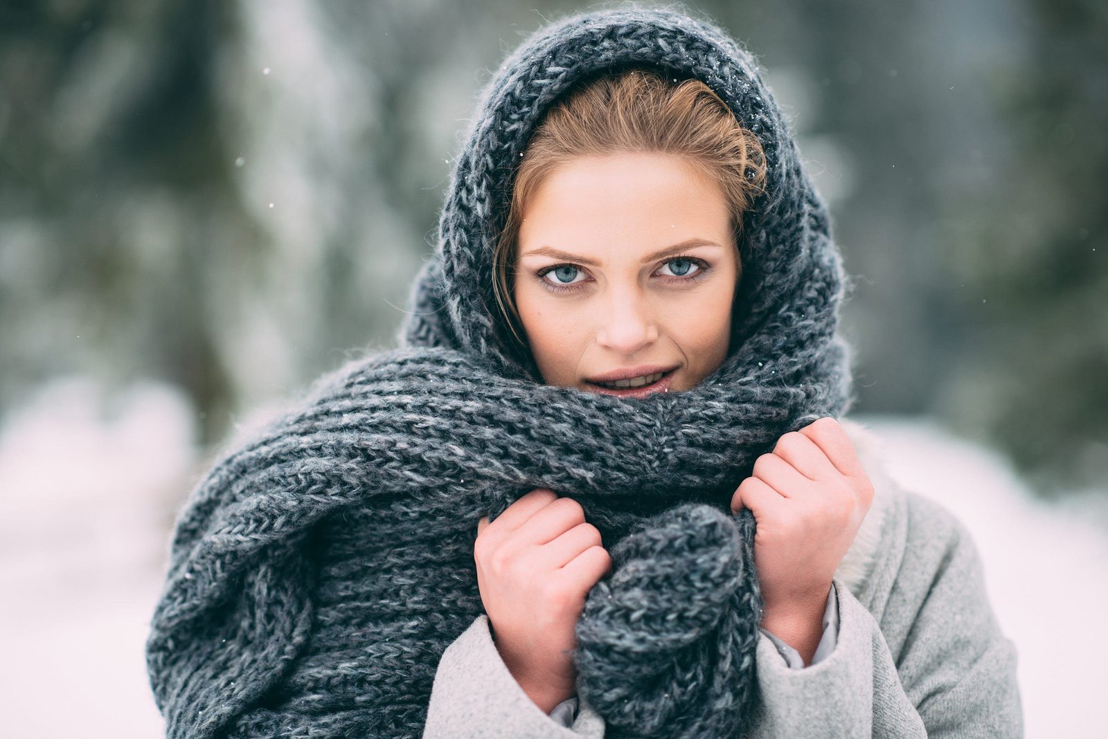 Woman wrapped in a blanket scarf as a statement layer for cold weather