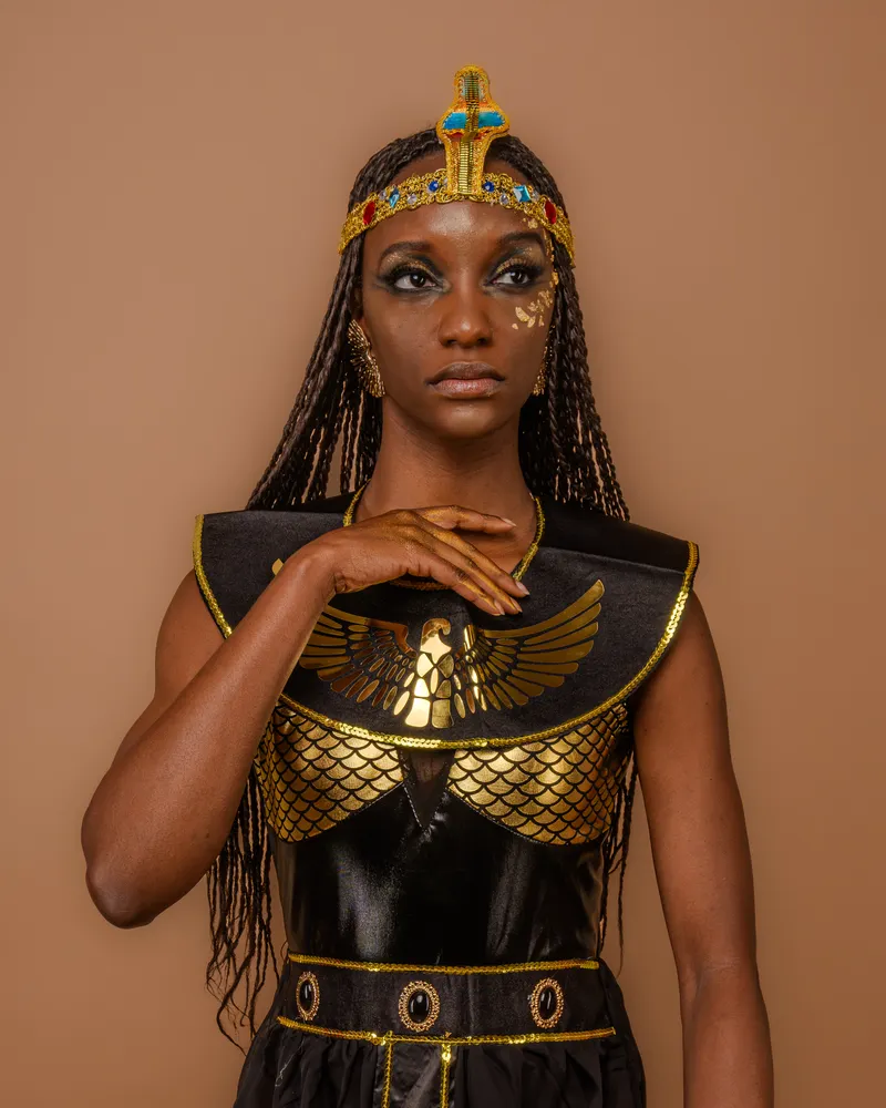 Black woman in a reimagined Cleopatra Halloween costume with gold jewelry