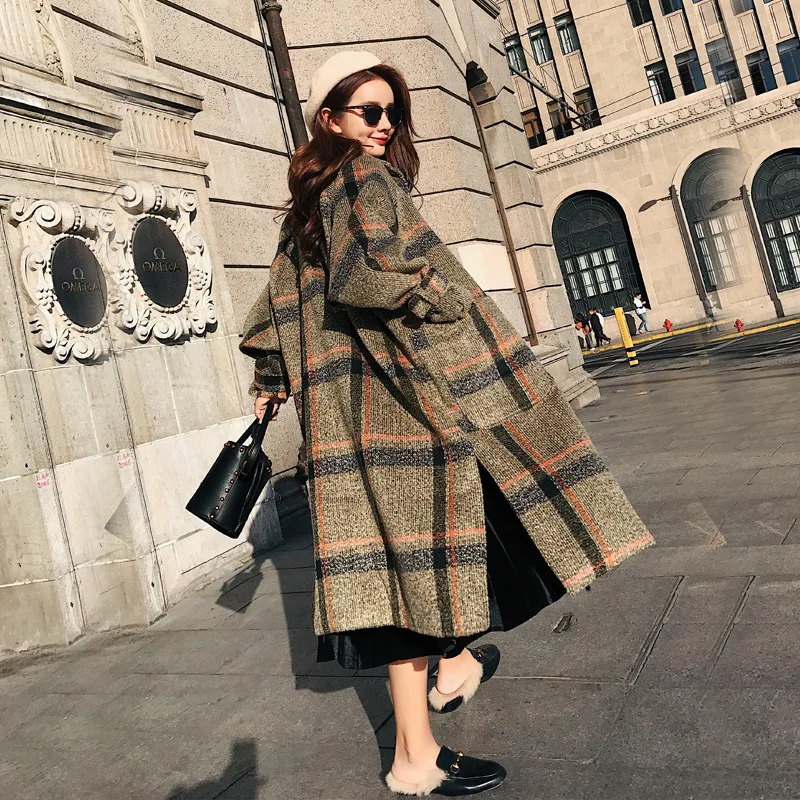 Woman wearing a long plaid wool coat over a fall outfit