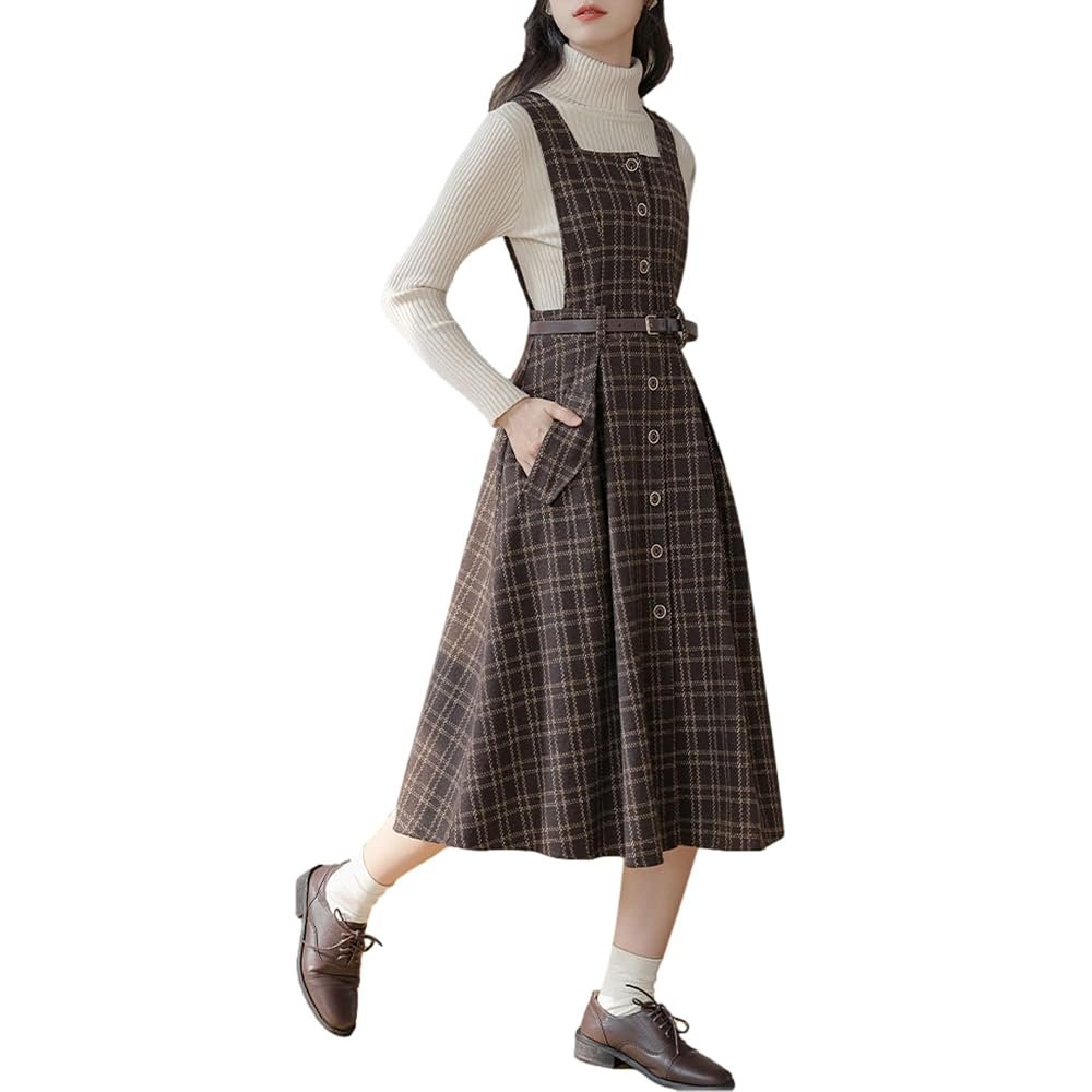 Woman wearing a plaid pinafore mini dress over a turtleneck