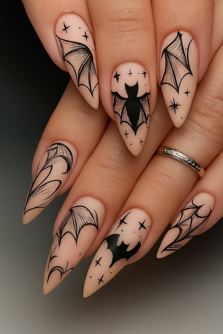 Minimalist black bat nail art on sheer nude nails