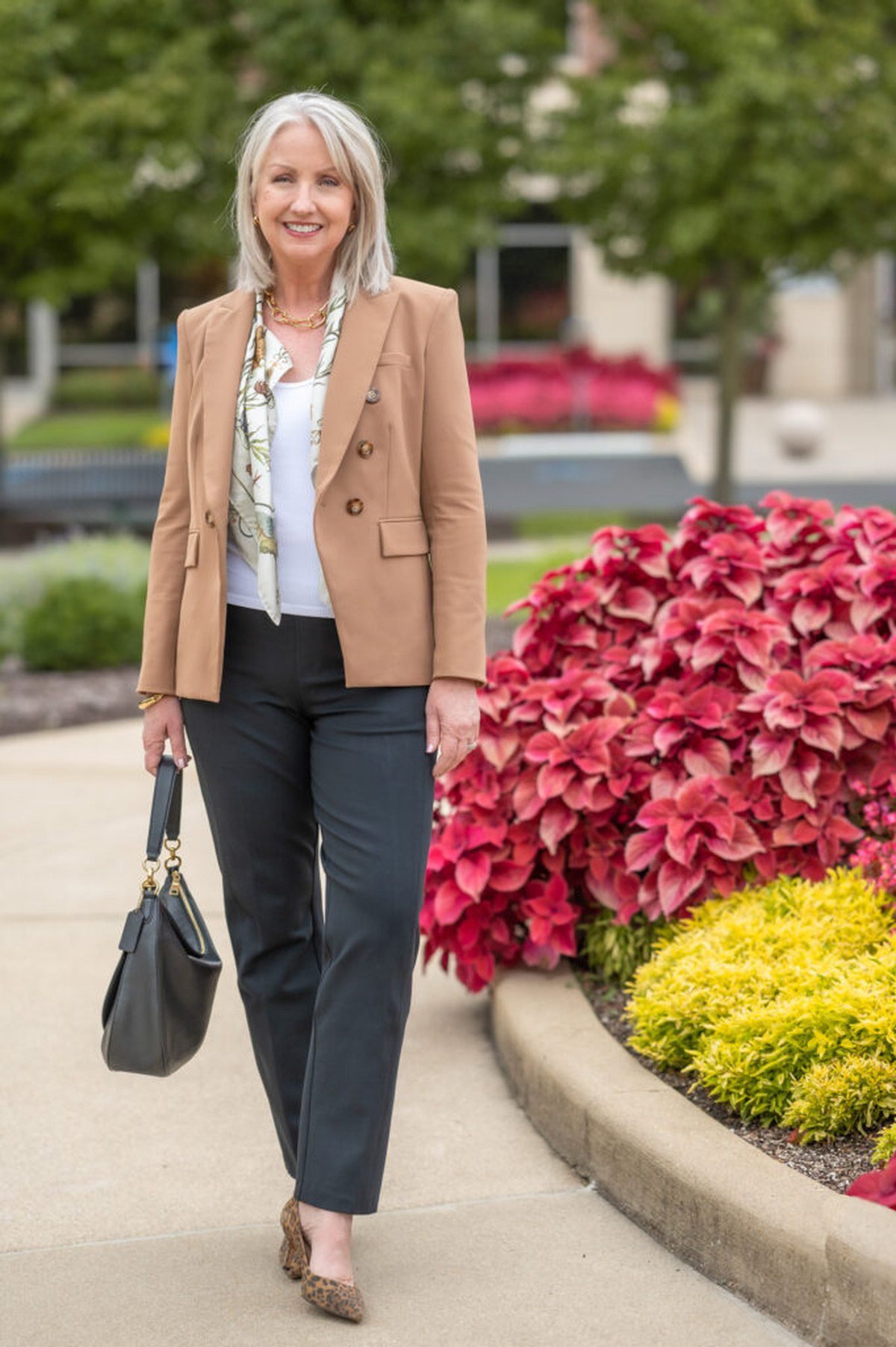 Woman over 40 in a charcoal wool shift dress with brown leather loafers