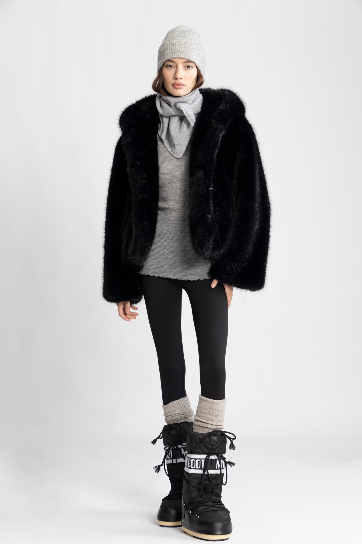 Woman wearing faux fur coat with leggings and chunky boots