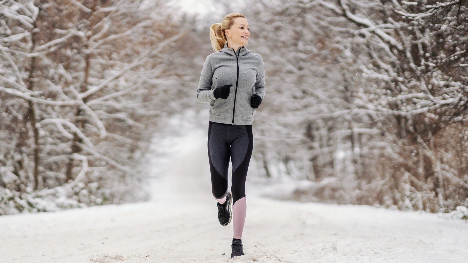 Woman in thermal running tights and windproof jacket winter workout