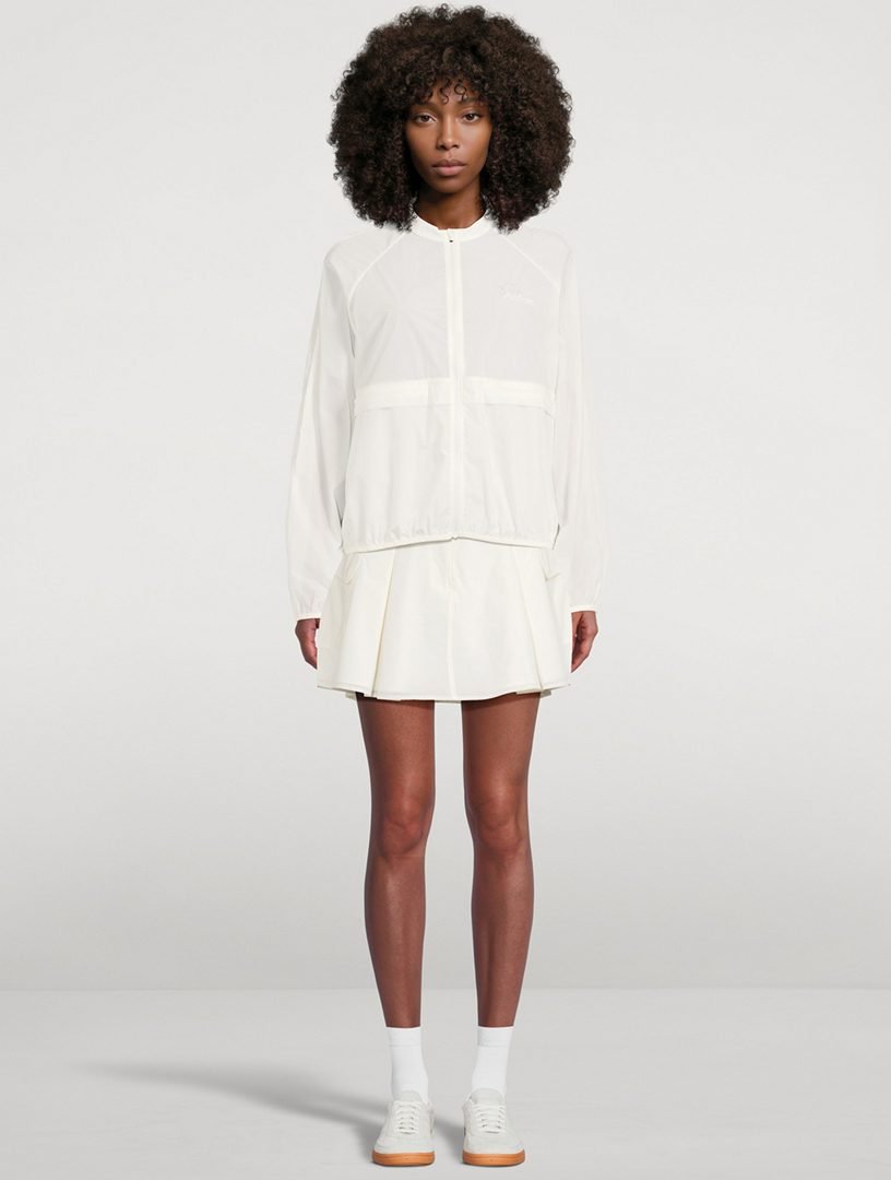 Woman in a pleated athletic skort with a windbreaker