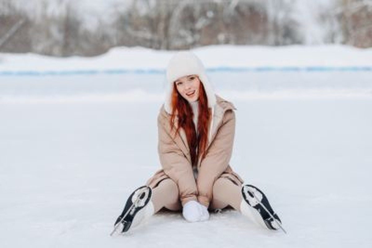 Woman in a puffer jacket ice skating in winter