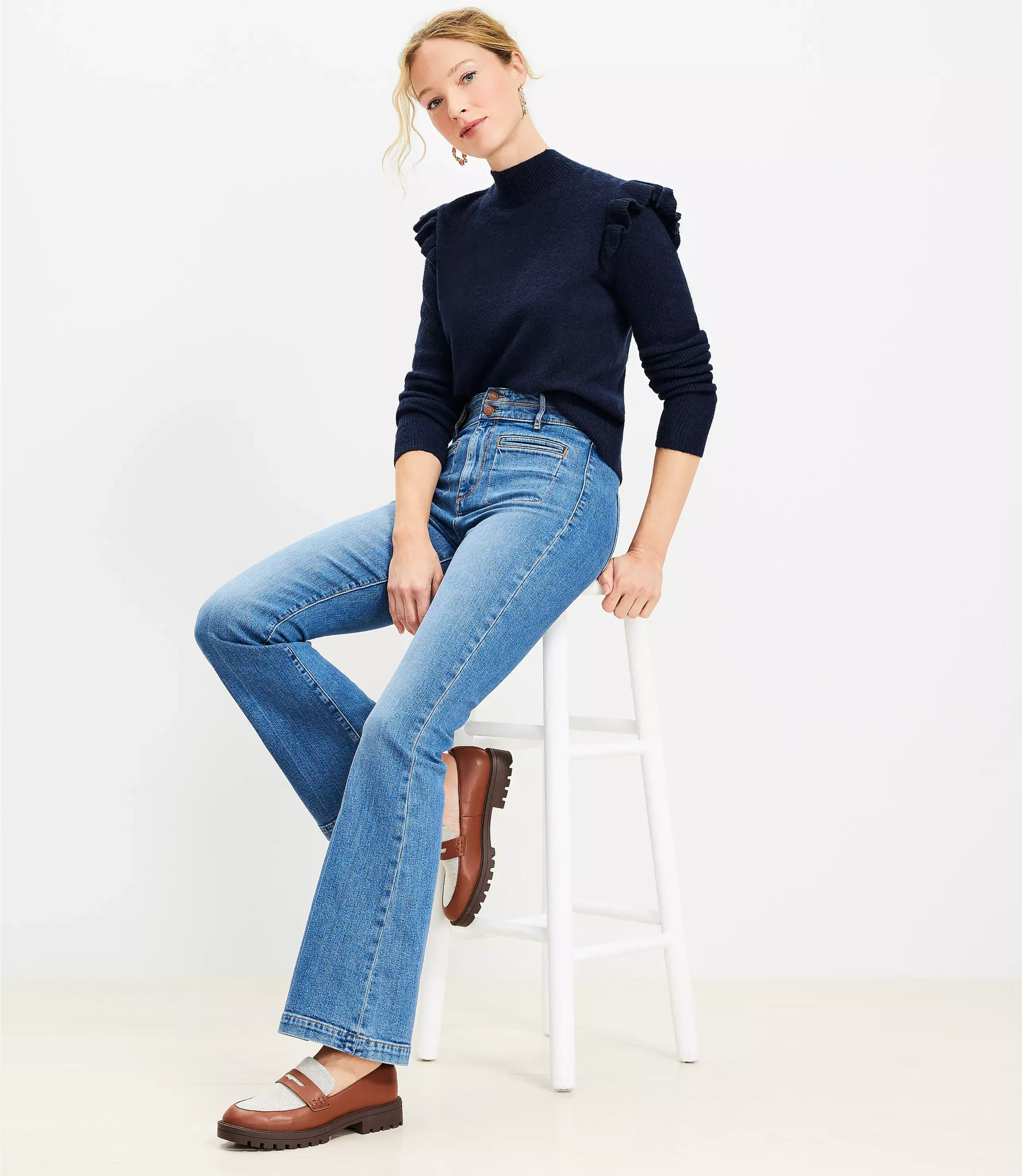 Woman wearing a mock-neck sweater with flare jeans and block heels, 70s style