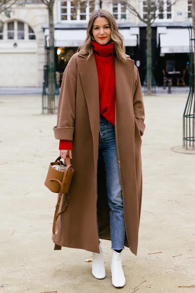 Woman wearing a turtleneck and jeans with a long camel wool coat