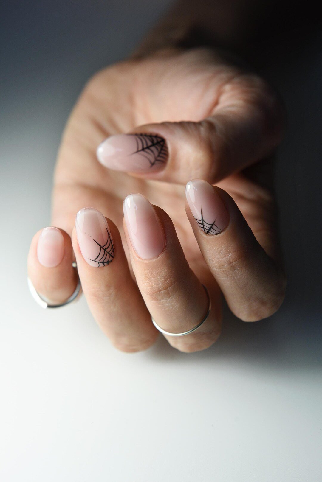 Subtle spiderweb nail art on nude elegant