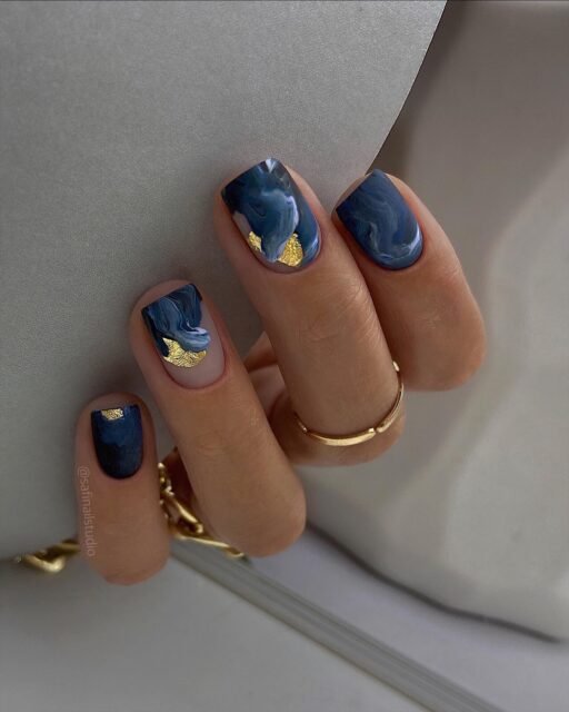 Deep navy nails with gold foil accent elegant