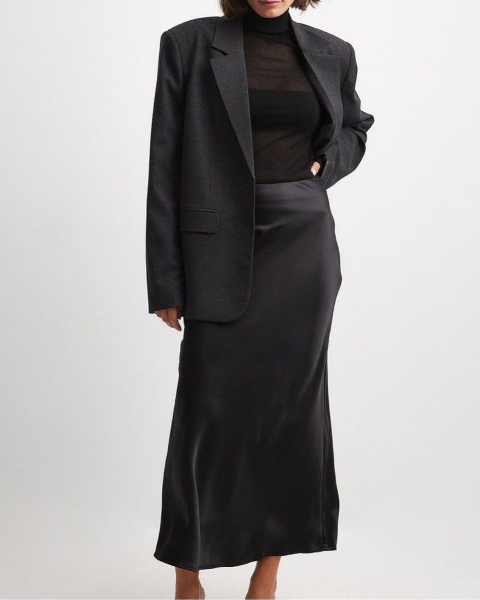 Woman in charcoal blazer with black satin skirt