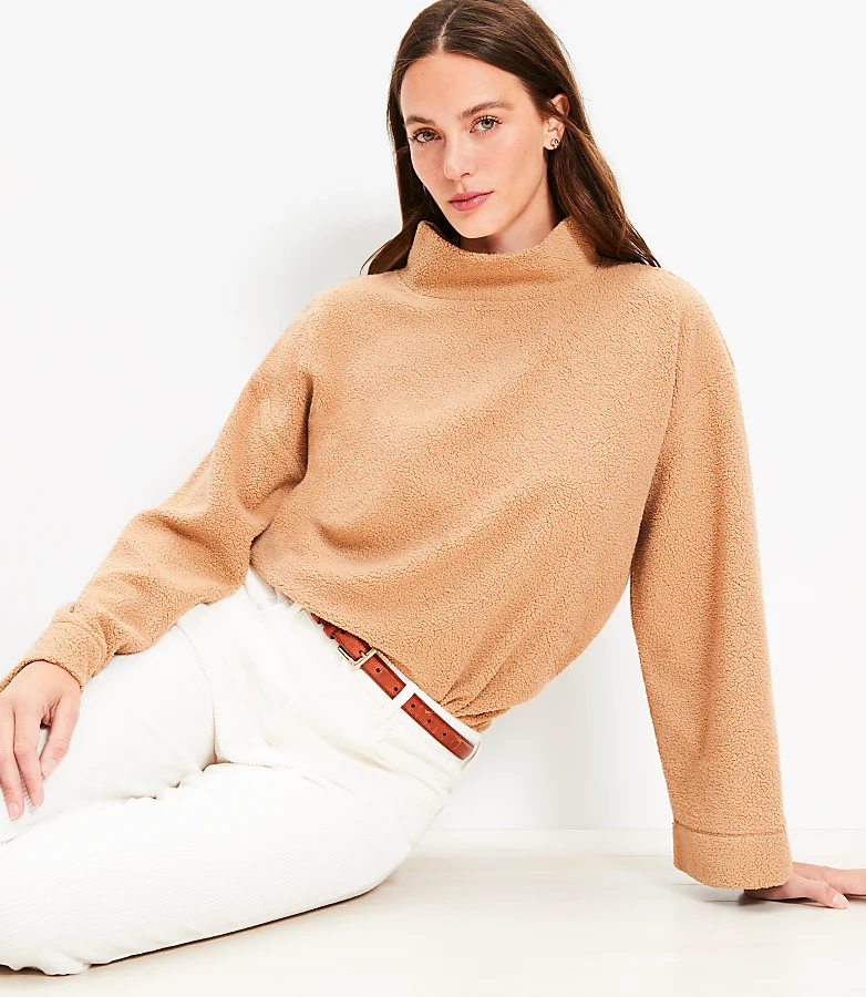Woman in ivory turtleneck and camel trousers