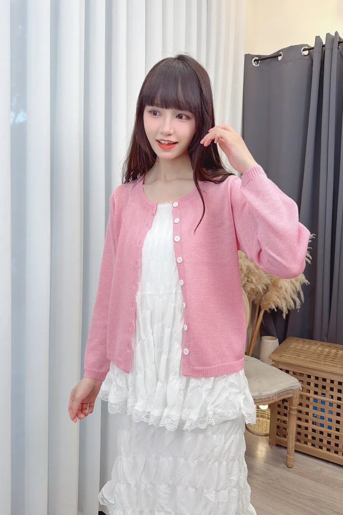 Woman wearing a ruffled formal gown with a cozy oversized cardigan