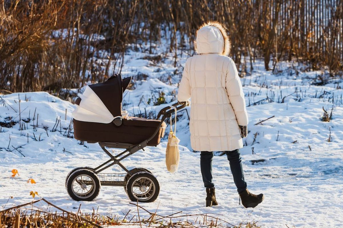 Mom in a stroller-friendly puffer coat for a cold game day