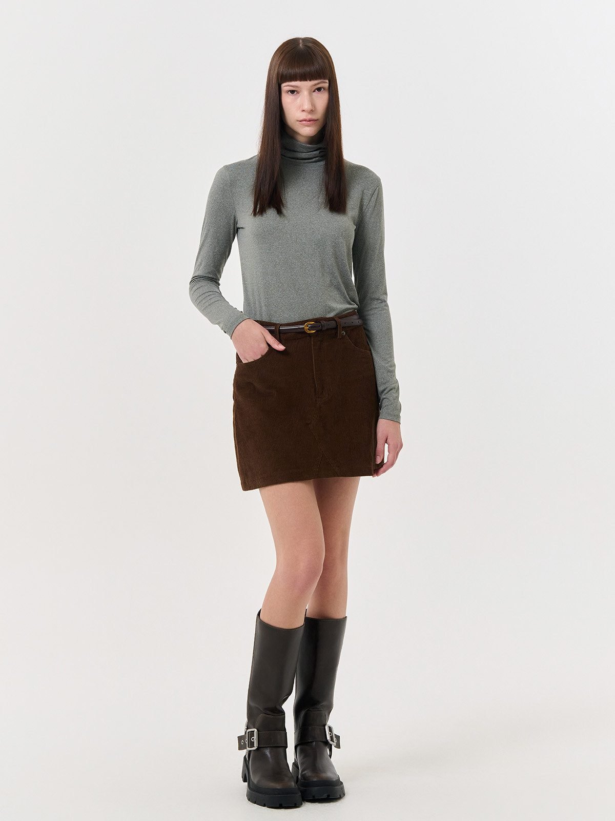 Woman wearing a corduroy mini skirt with a turtleneck