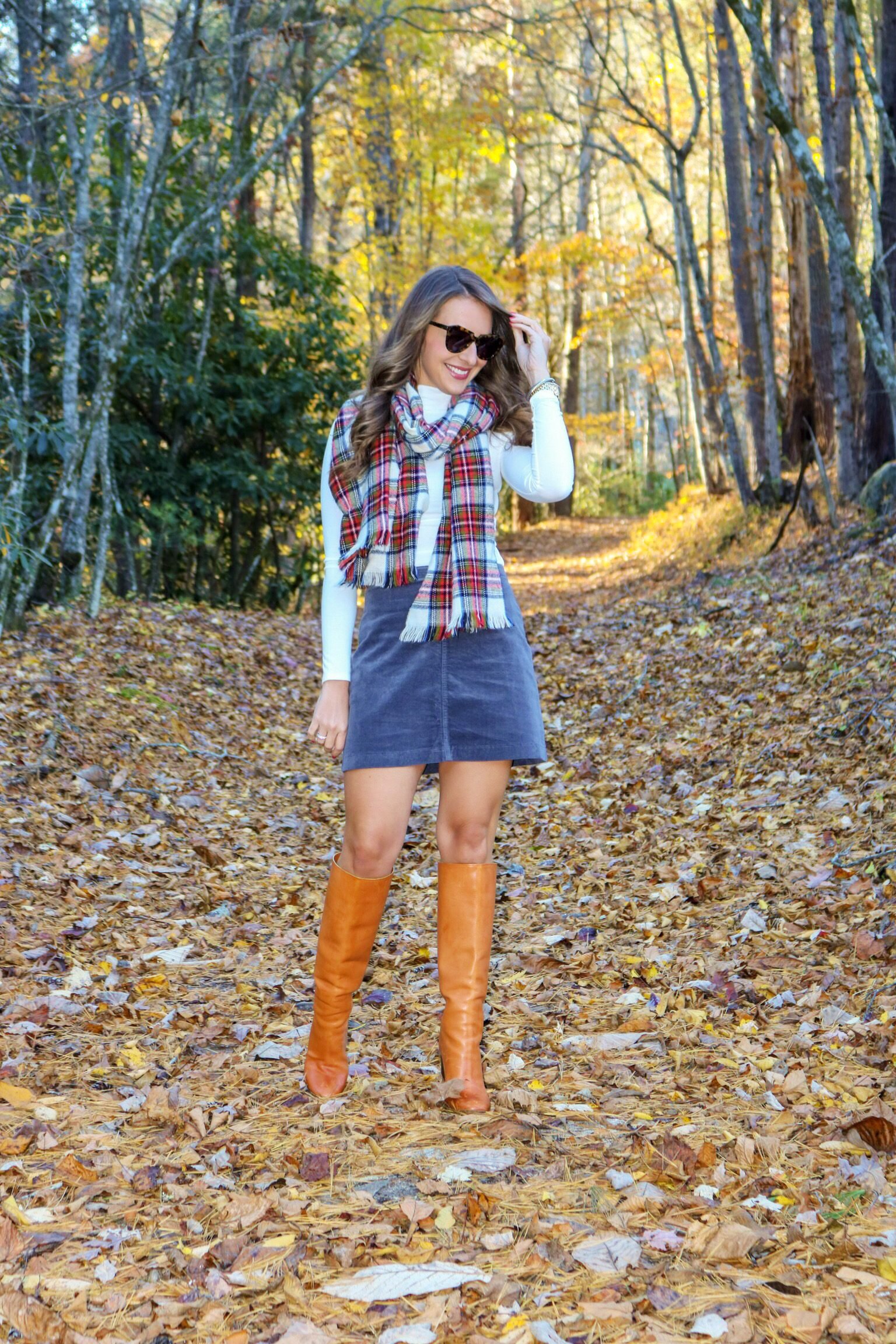 Woman in a plaid scarf with brown suede ankle boots autumn