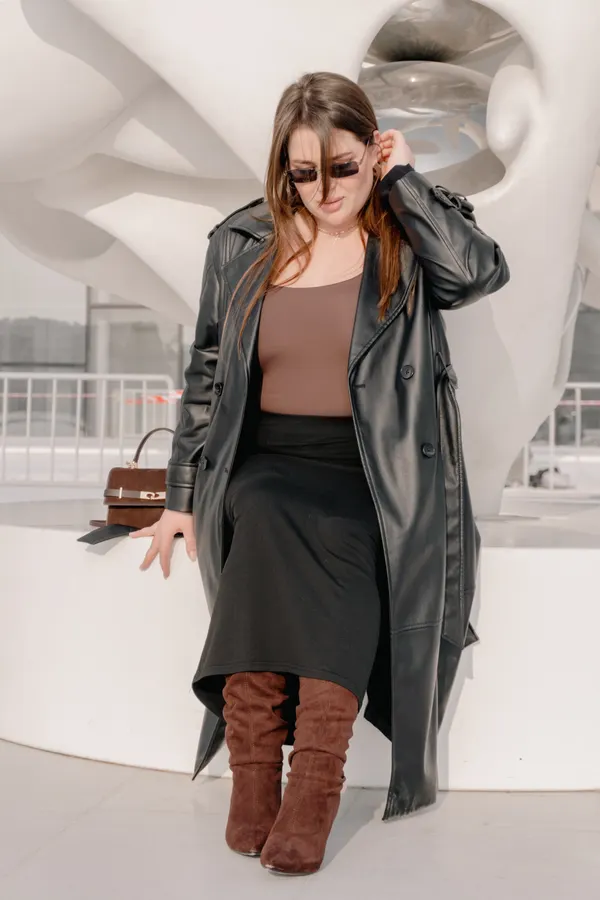 Woman wearing a midi skirt with slouchy brown suede boots