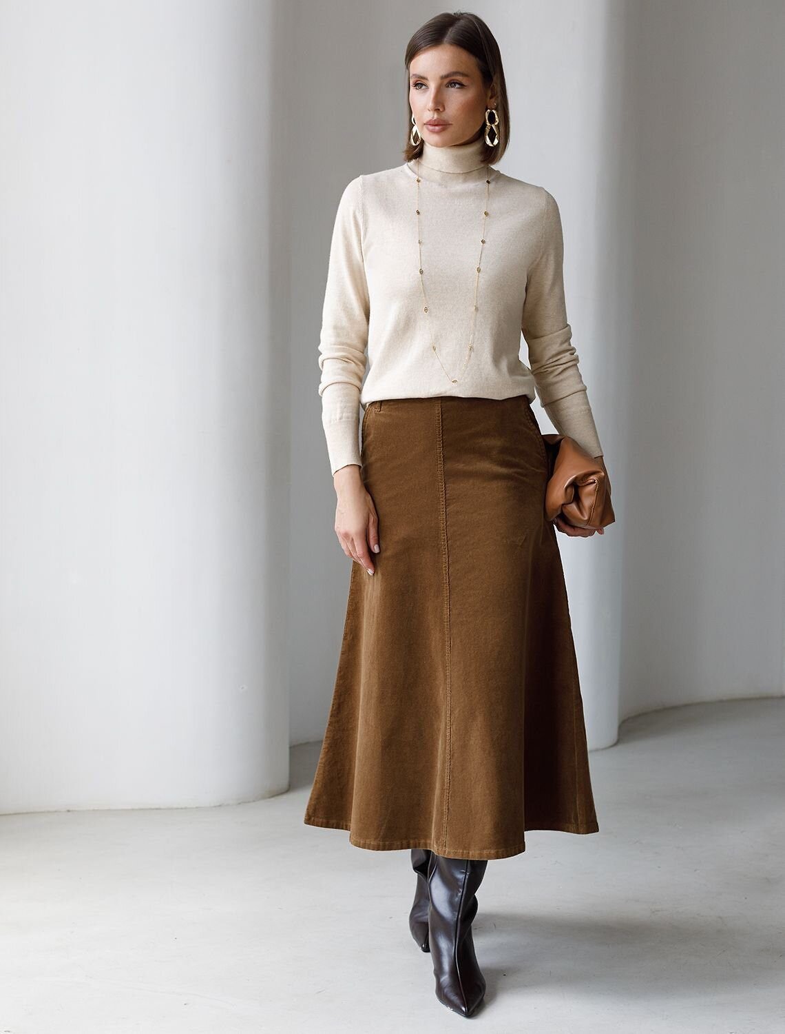 Woman wearing a corduroy midi skirt with a fitted turtleneck