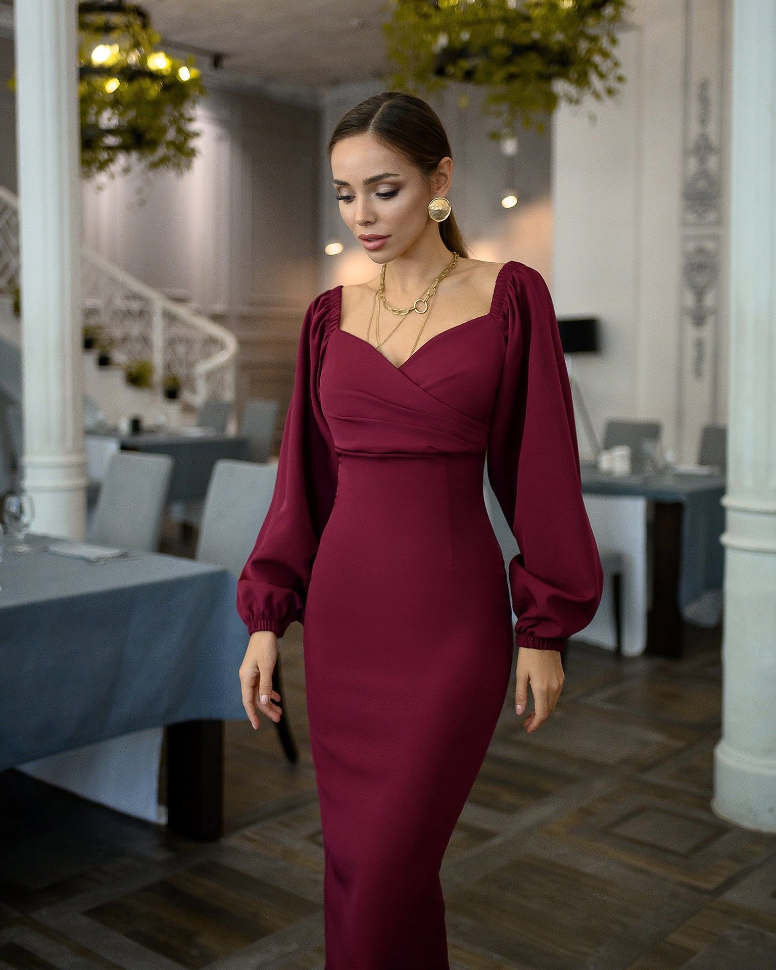 Woman wearing burgundy midi dress with gold jewelry