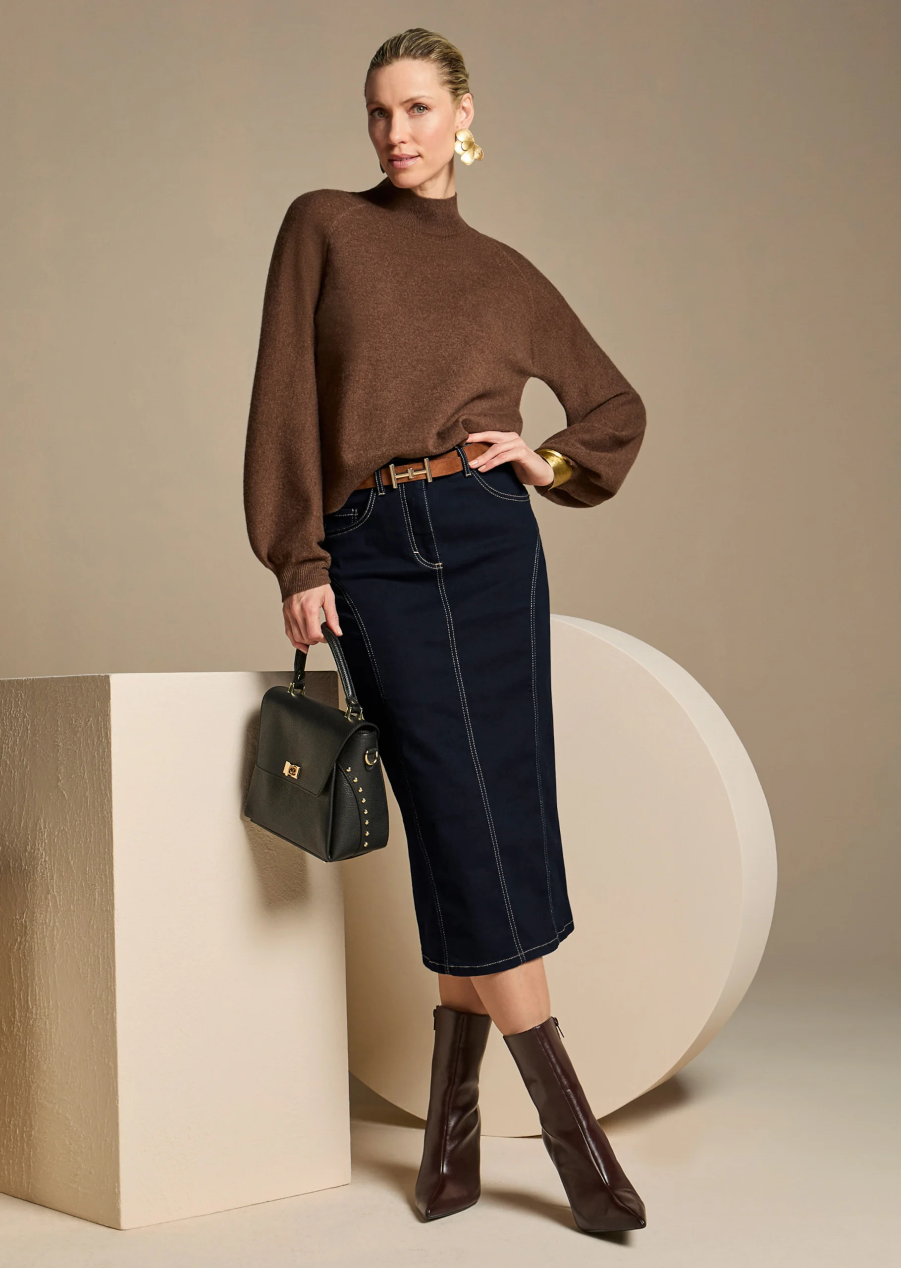 Woman in denim midi skirt with sweater and boots