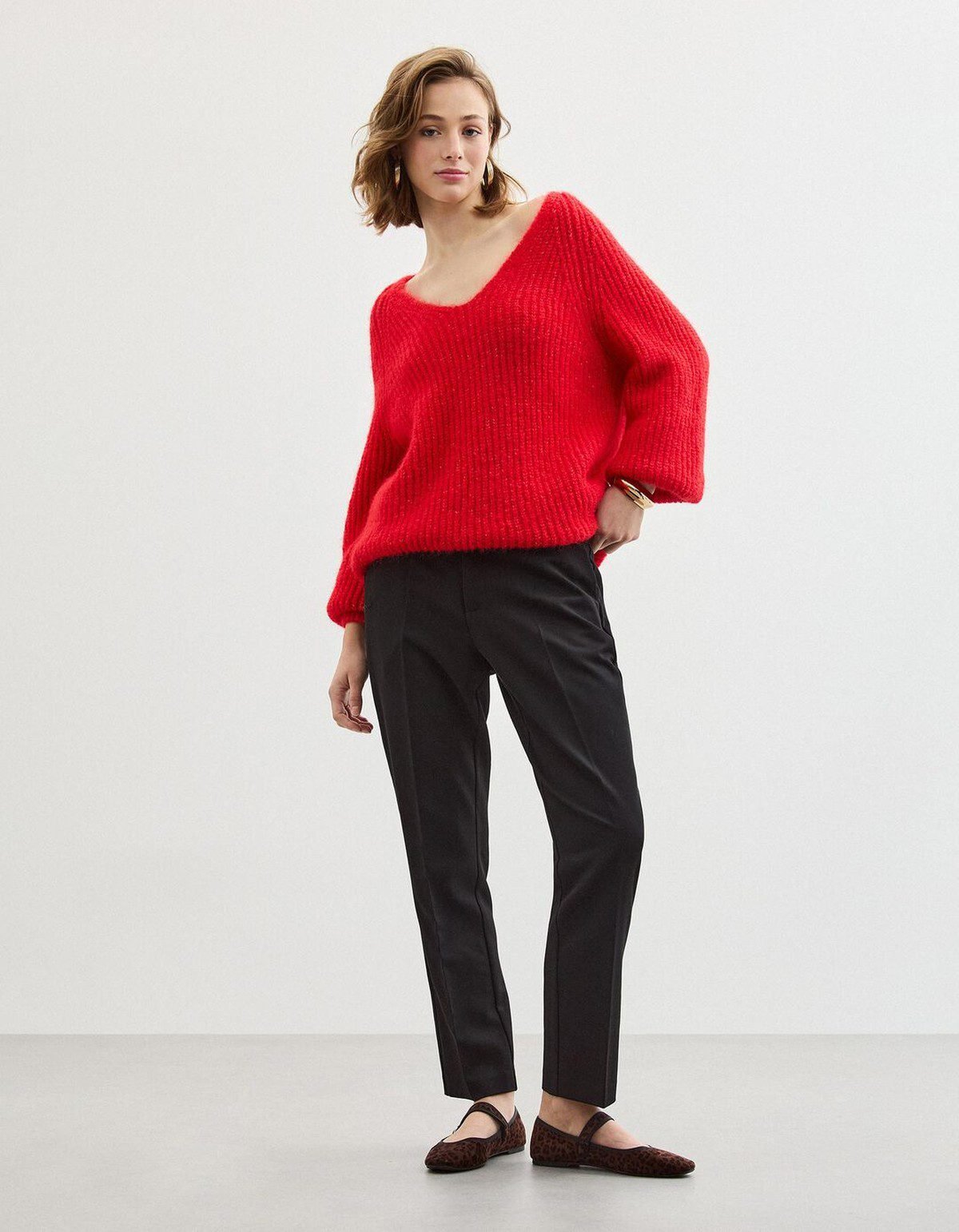 Woman in a red knit sweater with black trousers