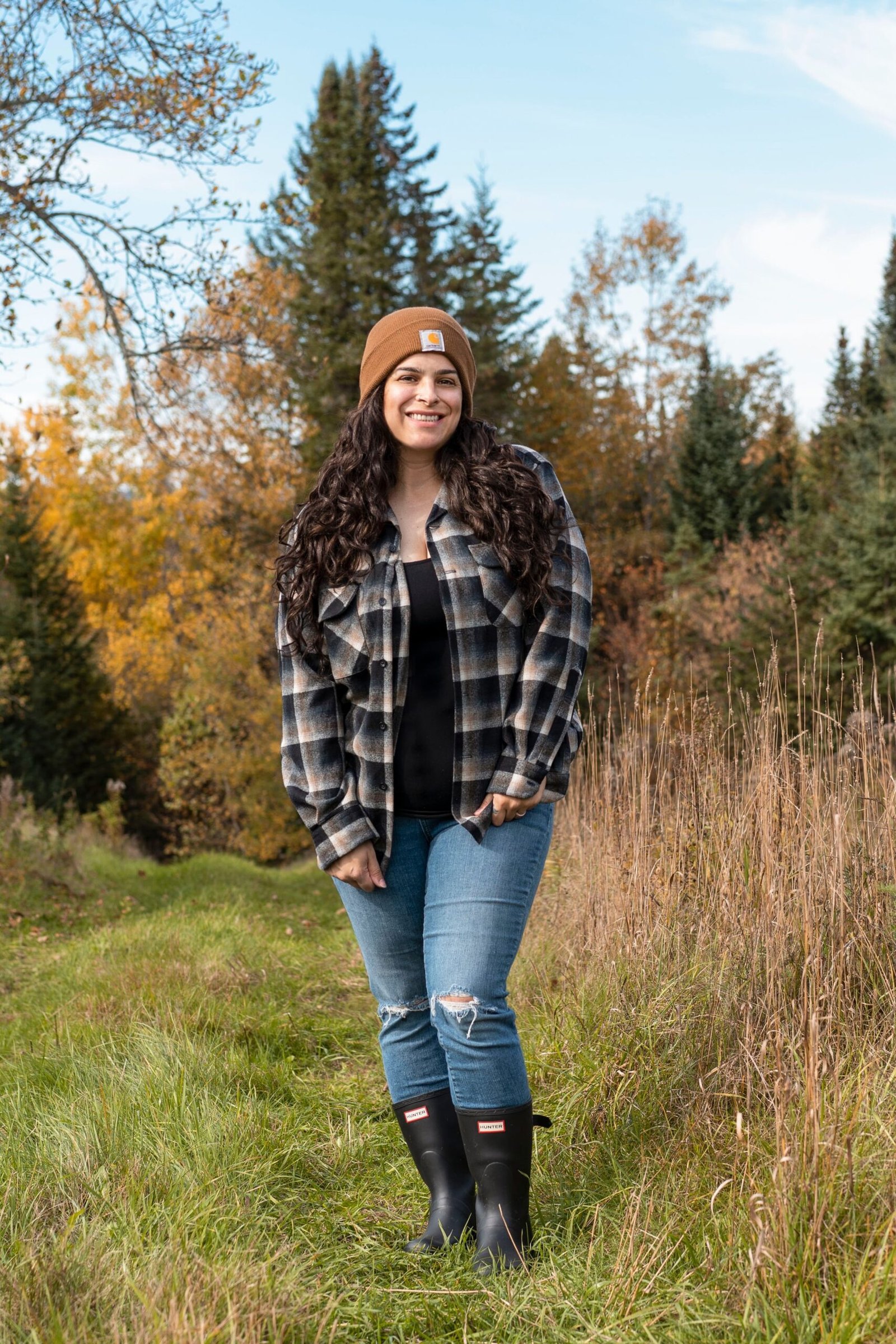 Woman in Hunter boots with a flannel shirt and quilted vest