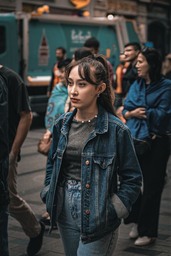 Woman wearing a formal gown with a denim jacket