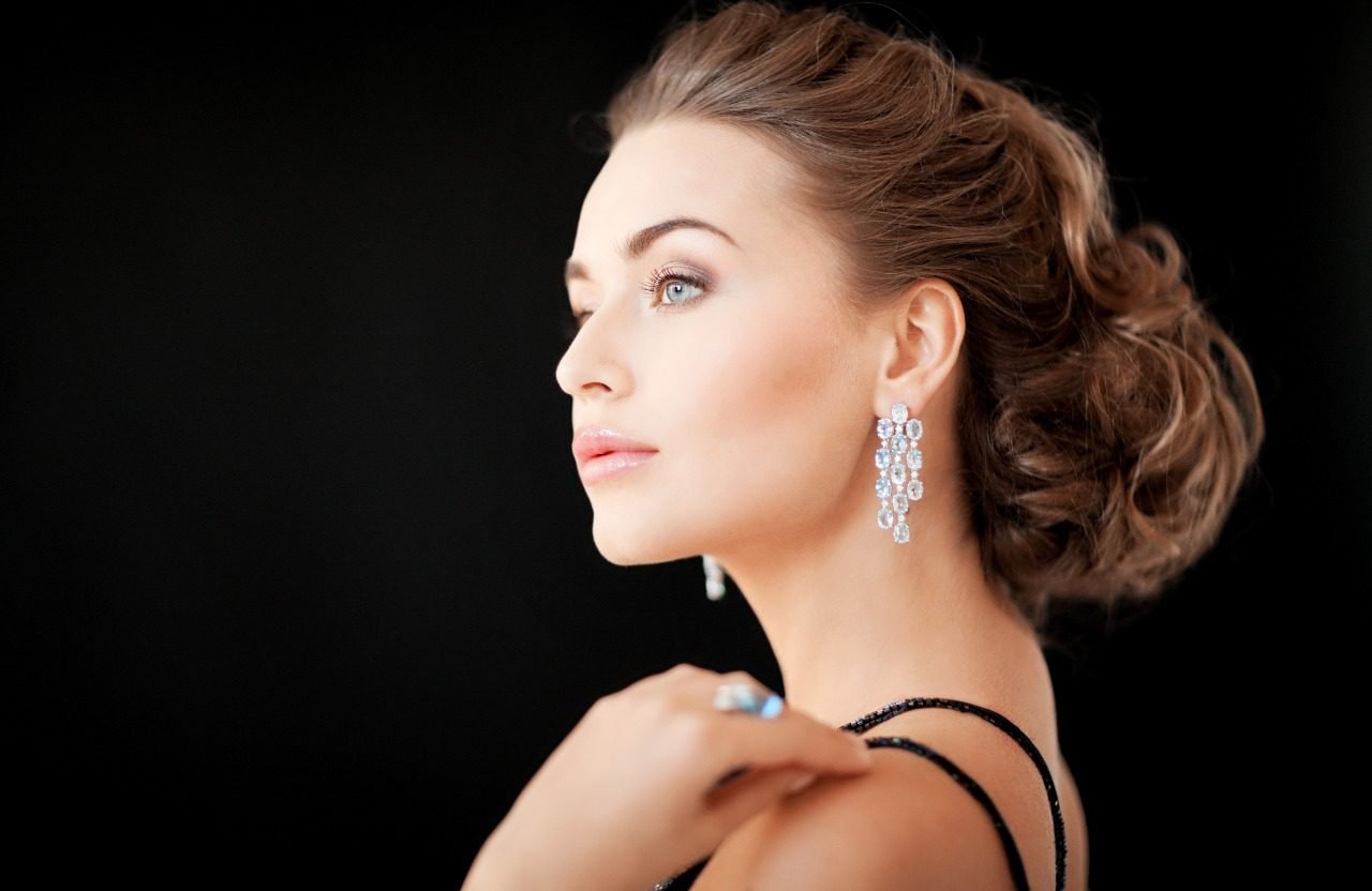 Woman wearing dramatic chandelier earrings with an updo, evening jewelry focus
