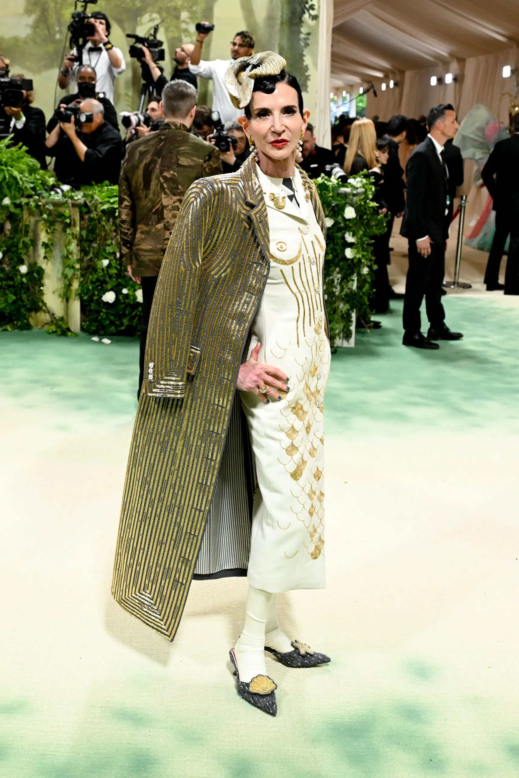 Woman wearing a floor-length embellished coat over a gown