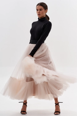 Woman wearing a blush tulle skirt with a fitted black top