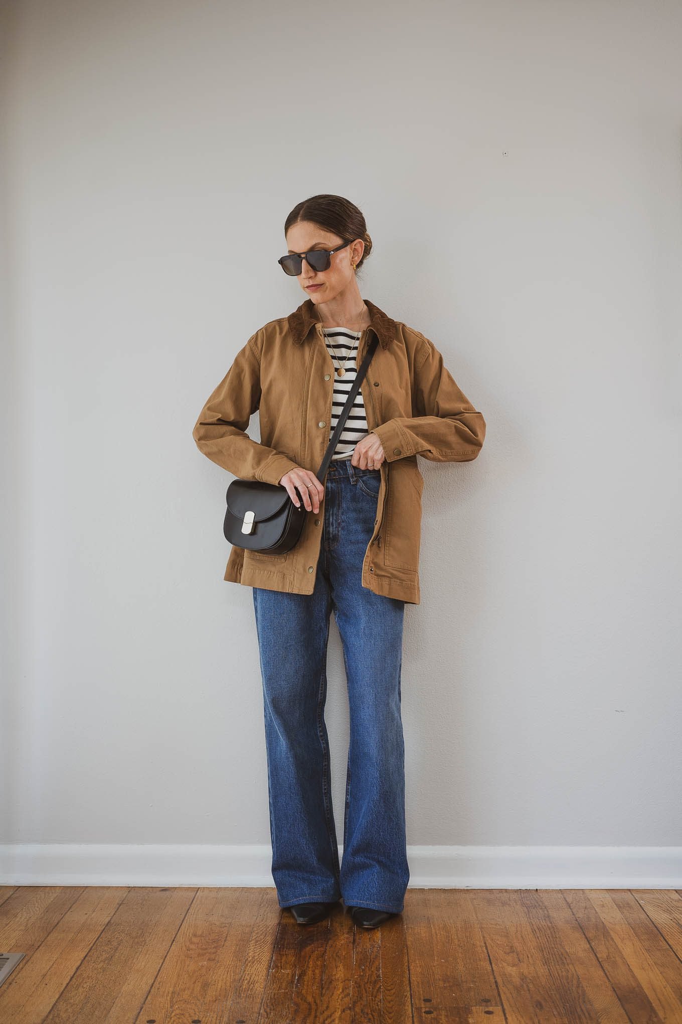 Woman in stone chore jacket with striped top and jeans