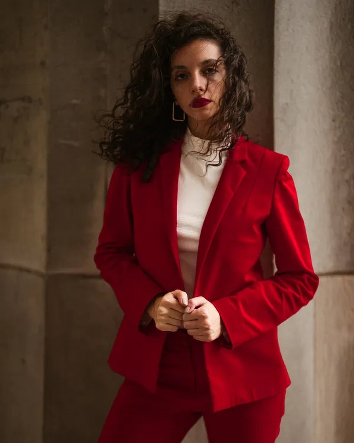 Woman wearing a bold red power-shoulder blazer with black trousers
