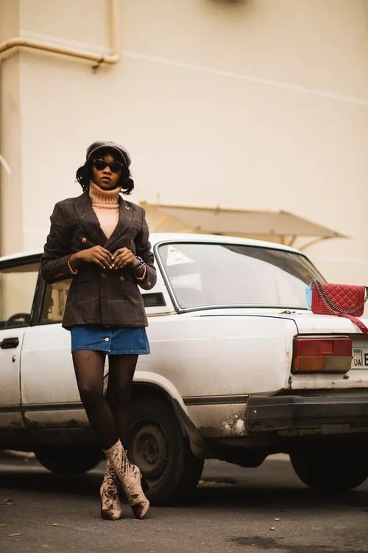 Woman wearing a power-shoulder blazer with a mini skirt and ankle boots