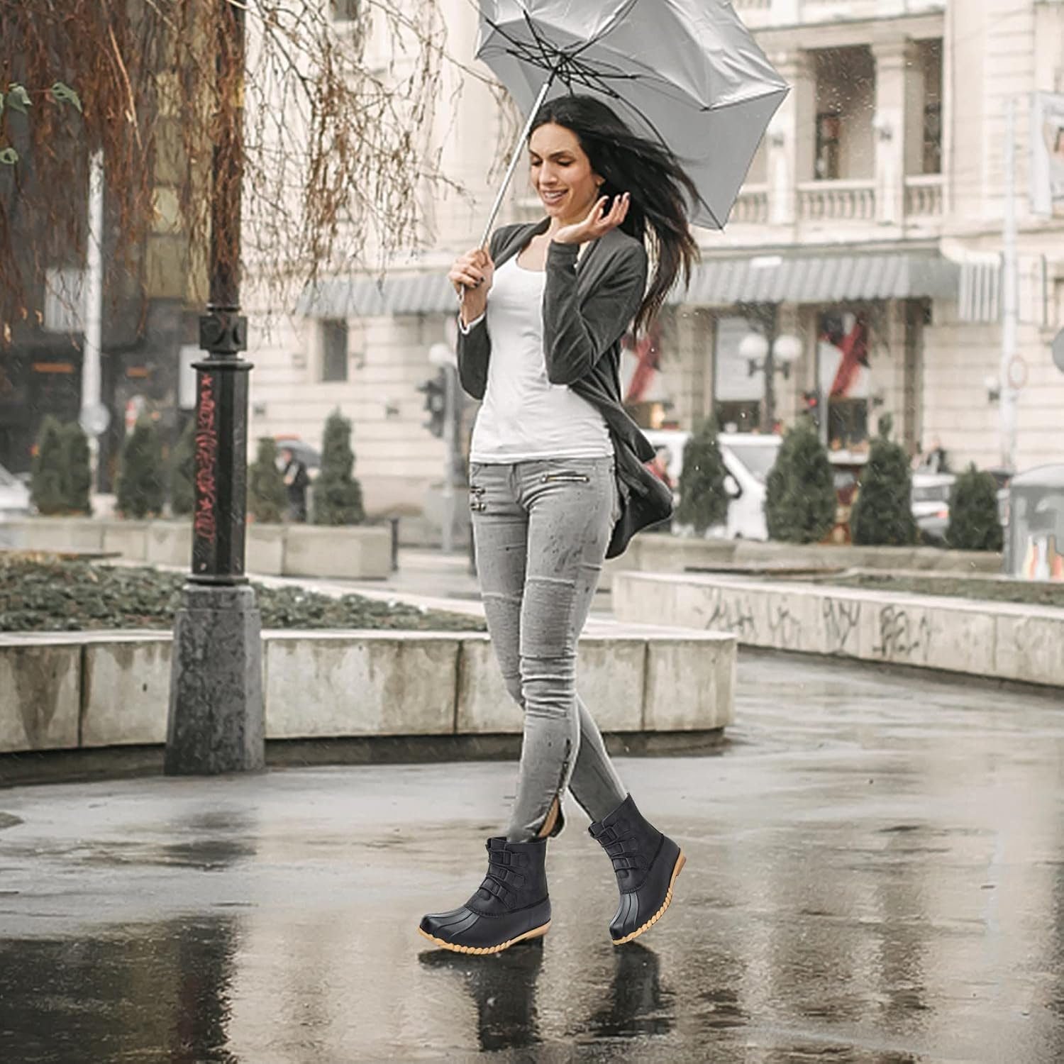 Woman wearing duck boots with cuffed jeans for a rainy game day