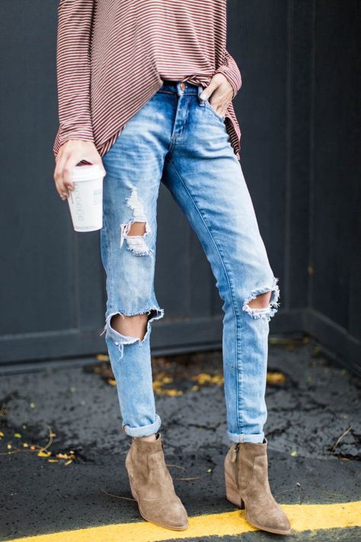 Woman in suede boots with distressed jeans for fall game day
