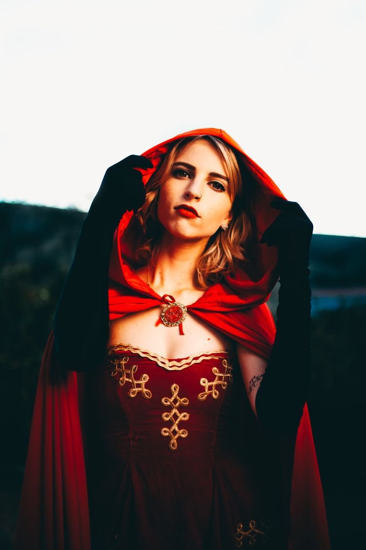 Woman in a red riding hood baddie Halloween costume with cape