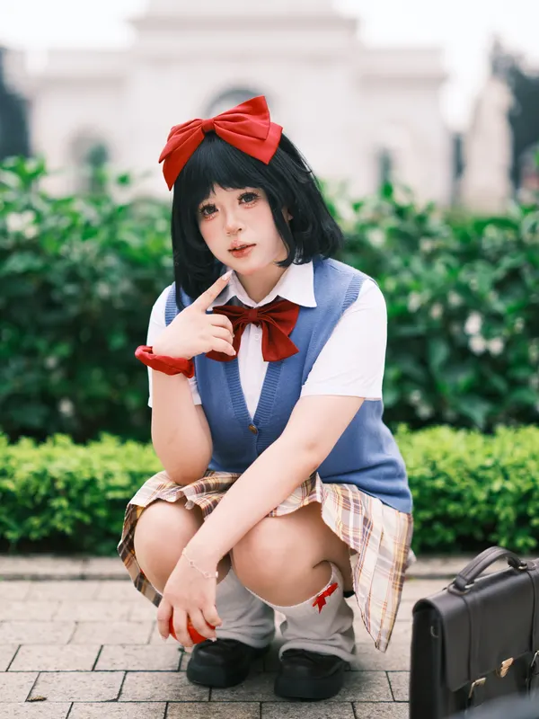 Woman wearing a schoolgirl baddie Halloween costume with plaid skirt