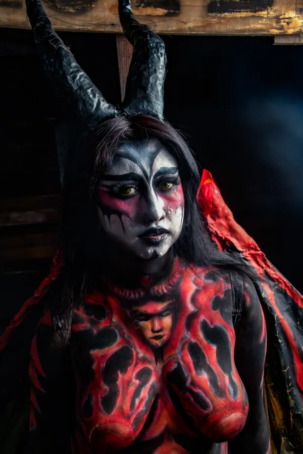 Woman wearing a red devil baddie Halloween costume with horns