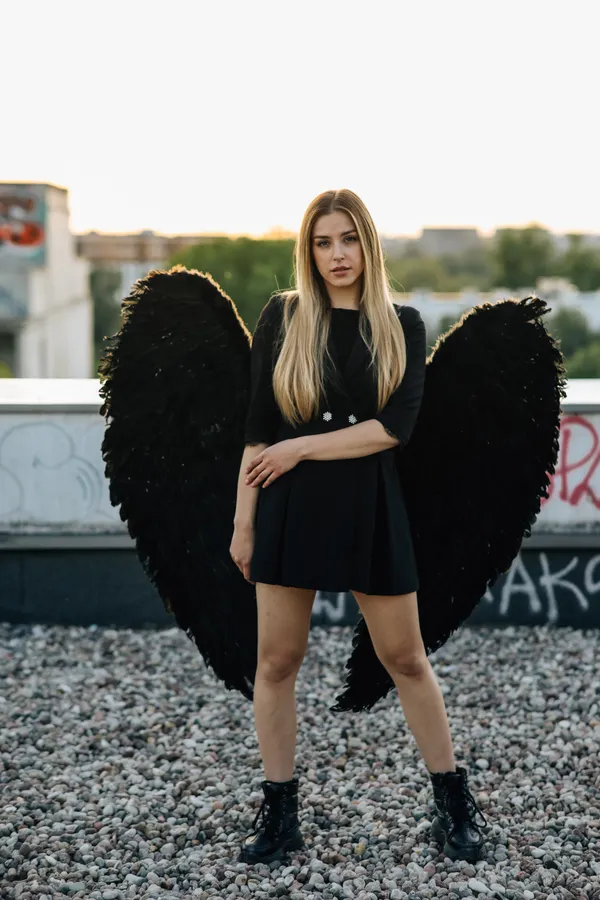 Woman in a dark angel baddie Halloween costume with black wings