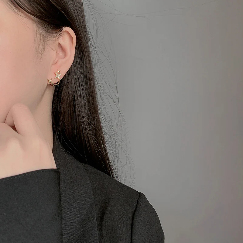 Woman wearing a tailored blazer with small star stud earrings, office outfit
