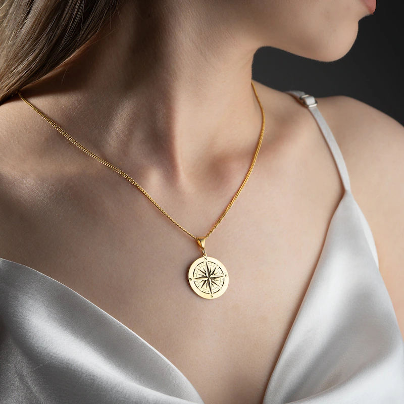 Woman wearing a silk camisole with a zodiac pendant necklace